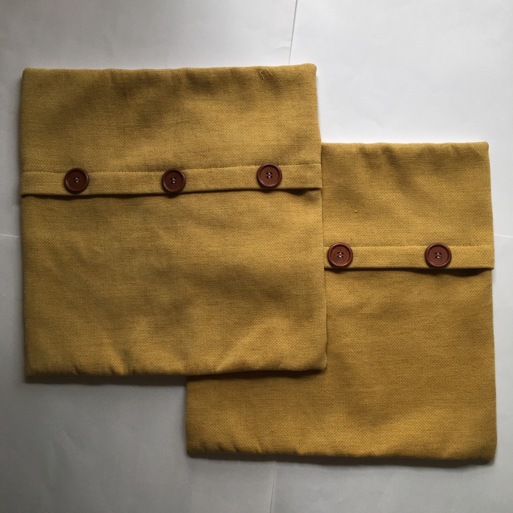 Two mustard color decorative pillowcases. 16x16.